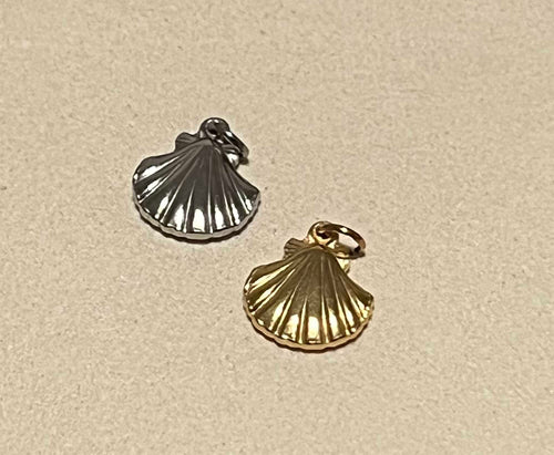 Shell shape charms in silver and gold on a beige background